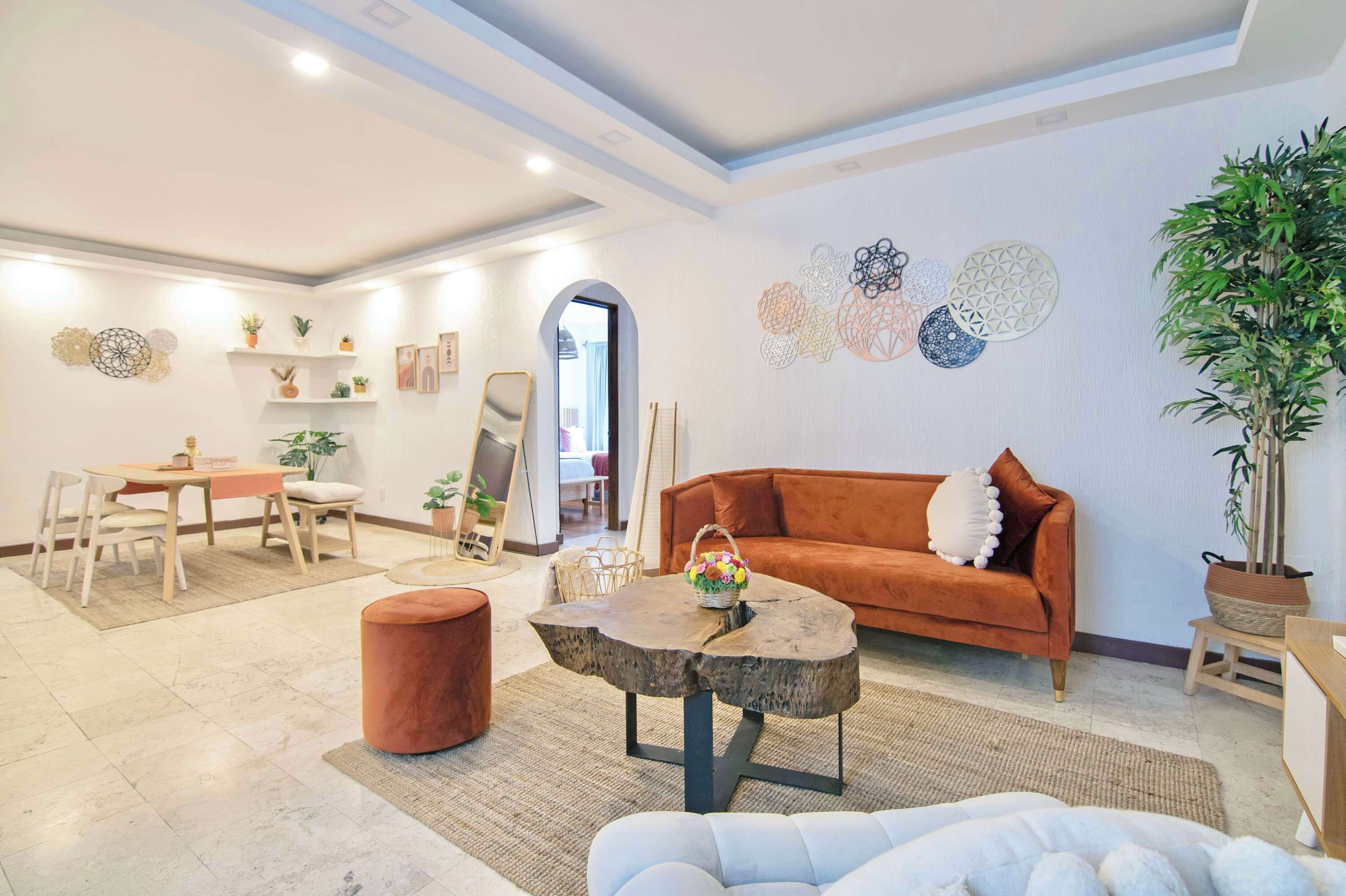 A modern living room with a sofa, coffee table, and dining area.