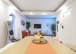 Une salle de conférence équipée d’une longue table, de chaises, d’un téléviseur et d’objets décoratifs.