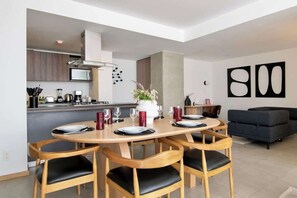 Een moderne keuken met een eethoek, een bank en abstracte wanddecoratie.