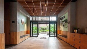 A spacious lobby with a wooden ceiling, a glass door entrance, and a bicycle-themed wall decoration. - Stunning High-Rise Panoramic Apartment Polanco 3BD (Ciudad de México)