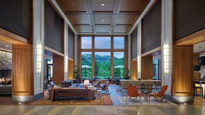 A spacious lobby with a large seating area, a fireplace, and a view of mountains through large windows. - Eagle River by Avantstay Located in the Westin (Avon)