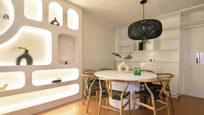 Ein stilvoller Essbereich mit einem runden Tisch, Holzstühlen und einem markanten Wanddesign mit integrierter Beleuchtung.