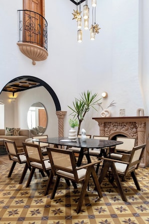 A dining area with a round table, chairs, and a decorative mirror.