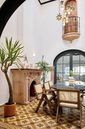 A dining area with a table and chairs, a fireplace, and a large window.
