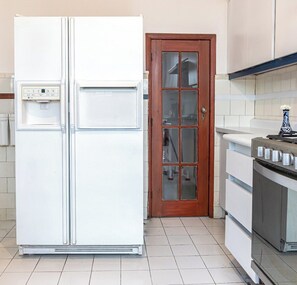 A kitchen with a white refrigerator, a wooden door, and a stove. - Beautiful house in Condesa with 2 terraces and 8bd (Ciudad de México)