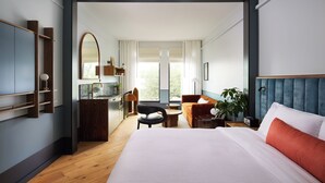 Een moderne hotelkamer met een groot bed, een bureau, een stoel en uitzicht op de omgeving.