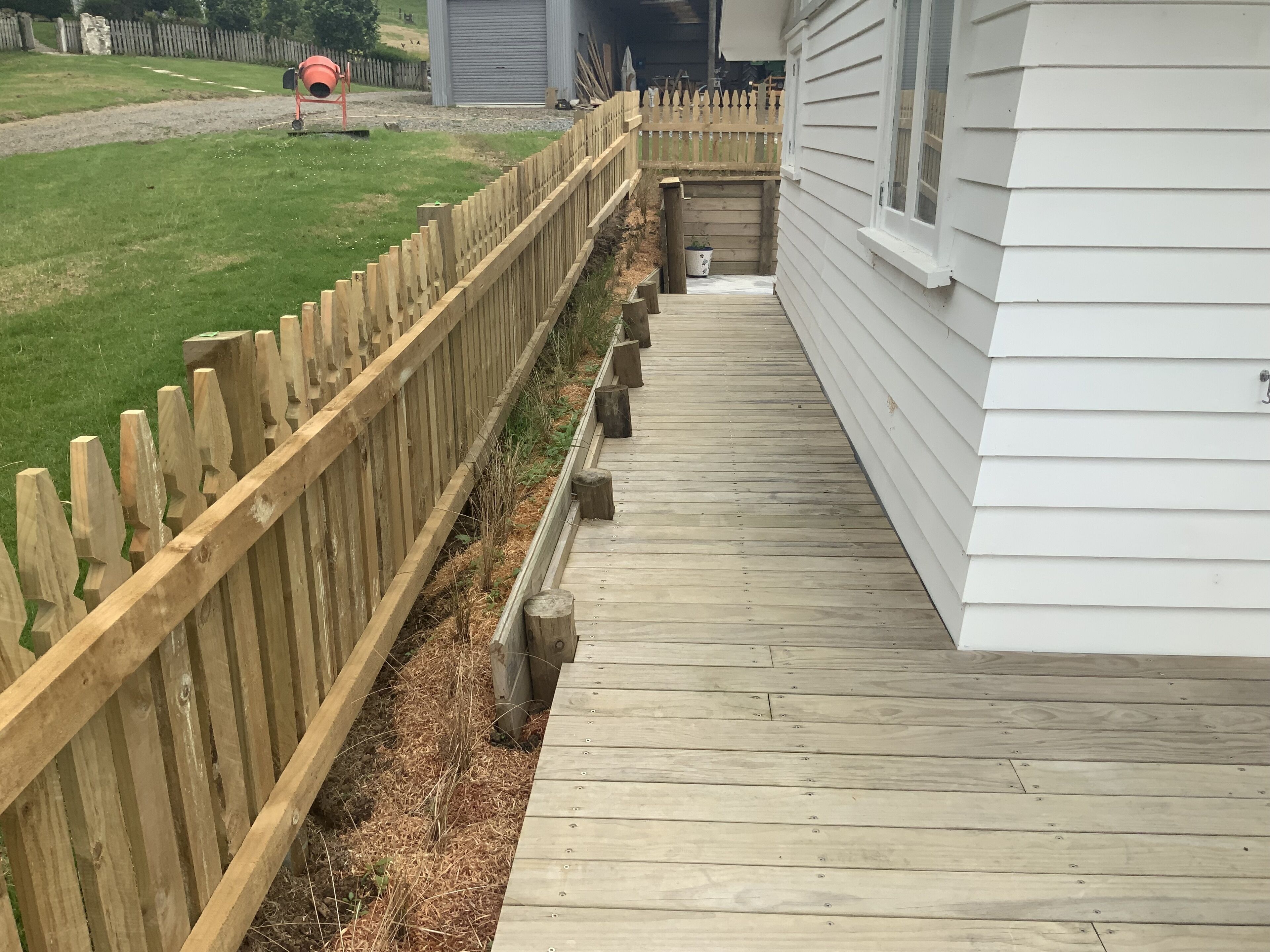 A wooden deck leading to a house with a white exterior.
