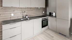 A modern kitchen with a stainless steel sink, a built-in oven, and light-colored cabinets. - Awesome apartment in Geilo with sauna (Geilo)