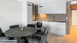 A modern kitchen with white cabinets, a built-in oven, and a wooden countertop. - Awesome apartment in Geilo with sauna (Geilo)