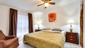 A bedroom with a bed, two nightstands, a ceiling fan, a chair, and a window with curtains. - 1 Mi to Lake Allatoona: Family Home on Farm! (Acworth)
