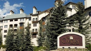 A multi-story hotel with a sign reading "The Charter at Beaver Creek."