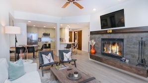 Una sala de estar moderna con chimenea, comedor y cocina.