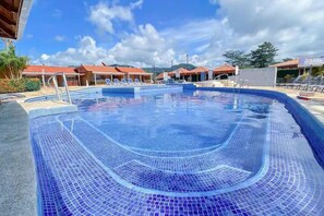 Relax by the pool surrounded by lounge chairs and umbrellas.
