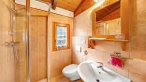Baño con ducha, inodoro, lavabo y ventana.