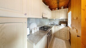 A kitchen with white cabinets, a granite countertop, a stove, and a sink.