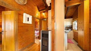 Een houten cabin met een centrale verwarming, houten wanden en een keukenhoek.