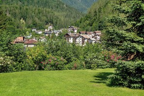 A hillside village with traditional houses, surrounded by lush greenery and trees.