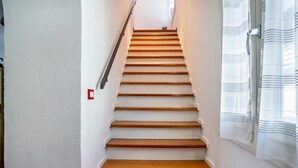 Een trap met houten treden en witte muren.