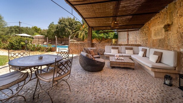 An outdoor patio with a round table, chairs, a sofa, and a wicker chair. - Country House 'Cugulutx' with Private Pool, Private Terrace and Wi-Fi (Llucmajor)