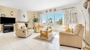 A living room with a sofa, armchair, and a coffee table. - Villa 'Casasilma' with Sea View, Wi-Fi and Air Conditioning (POBLE NOU DE BENITATXELL)