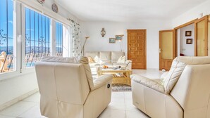 A living room with a sofa, armchairs, a coffee table, and a view of the outdoors. - Villa 'Casasilma' with Sea View, Wi-Fi and Air Conditioning (POBLE NOU DE BENITATXELL)