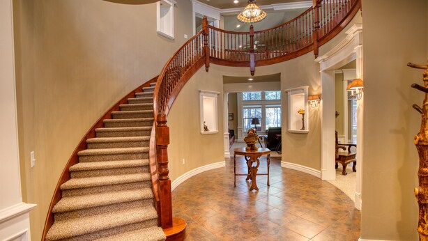 A grand staircase with a wooden railing leading to a second floor. - Luxury Family Retreat w/ Views, Golf: Fore Seasons (Pinetop)