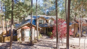 A two-story house with a stone facade, surrounded by tall pine trees. - Luxury Family Retreat w/ Views, Golf: Fore Seasons (Pinetop)