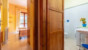 Baño con lavamanos, inodoro y zona de ducha.