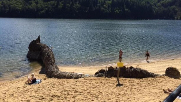 A beach with a large rock formation, a sandy shore, and a forested hill in the background. - Apartment 'Le Grenier D'annick' with Mountain View, Private Terrace and Wi-Fi (Villefort)