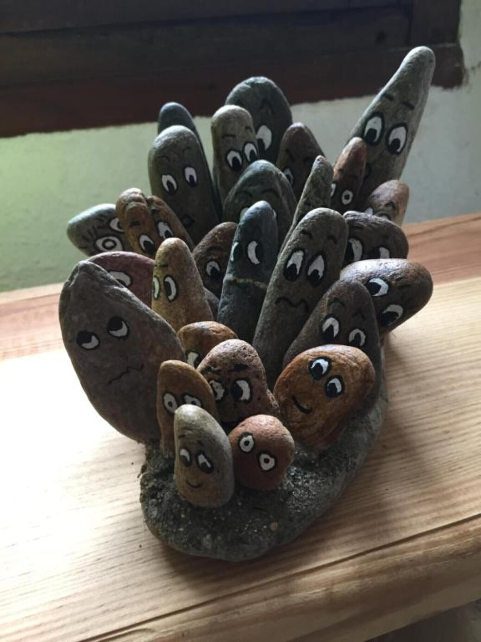 A collection of rocks with faces painted on them.