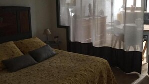 Een slaapkamer met een bed, een bureau en een stoel.
