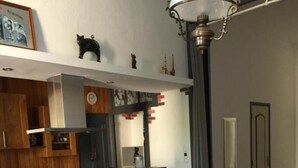 Een moderne keuken met een vast kookeiland, een eethoek met een ronde tafel en stoelen, en een kleine ronde tafel op de voorgrond.