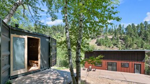 A cabin with a wooden deck and a large window. - Crate Escape at Terry Peak (Lead)
