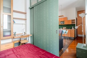 1 dormitorio y tabla de planchar con plancha