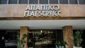 Das Gebäude von Atlantic Flat Service mit moderner Gestaltung, mit großen Glasfenstern und Pflanzenkübeln im Eingangsbereich.