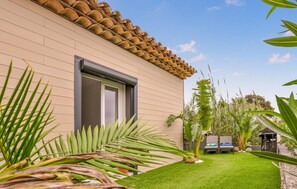 A house with a tiled roof, a window, and a well-maintained lawn with two lounge chairs. - Beach front home in Cavalaire-sur-Mer with WiFi (Cavalaire-sur-Mer)