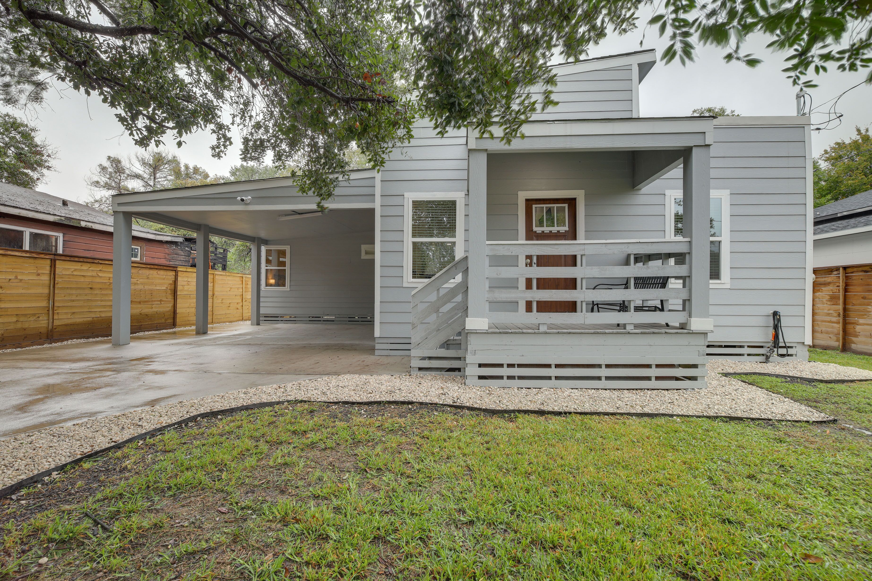 A modern two-story house with a covered porch and a staircase leading to the upper level.