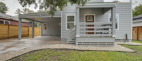 A modern two-story house with a covered porch and a staircase leading to the upper level.