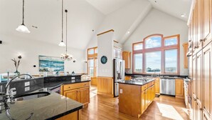 Una cocina amplia con armarios de madera, una isla grande y vistas a la ciudad.