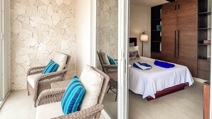 A room with wicker furniture, a bed with a white bedspread, a ceiling fan, and a stone wall.