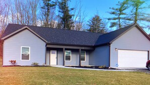 A two-story house with a garage, a front porch, and a well-maintained lawn. - Close to everything-tucked away from the noise. A brand-new, blissful stay. (Ithaca)