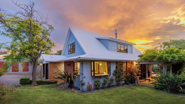 A two-story house with a sloped roof, large windows, and a well-maintained lawn. - Comfort, Style, Relaxation. Your Home Away from Home Awaits! (Blenheim)