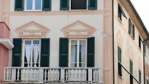 A building with a balcony, green shutters, and a classic architectural style. - Lovely apartment for 5 people with TV (Noli)