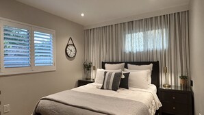 A bedroom with a bed, a bedside table, a nightstand, a wall clock, and a window with blinds. - 1-Bd 1-Bth Apt, Disney & Anaheim Conv Ctr in 10 Mins! Full Kitchen & Outdr Space (Santa Ana)