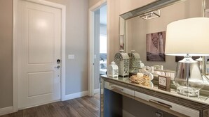A bathroom with a large mirror, a vanity with a glass top, and decorative items on the counter. - Luxurious Family Home - Spacious Kitchen & BBQ (Pompano Beach)