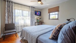 A bedroom with a bed, a desk with a chair, a ceiling fan, and a TV on the wall. - Comfy 3Bedrooms 2Bathrooms Excellent Location Home near to Downtown Pittsburgh (Pittsburgh)