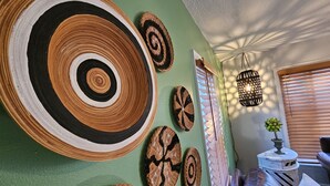 Una habitación con una pared verde decorada con tapices circulares tejidos.