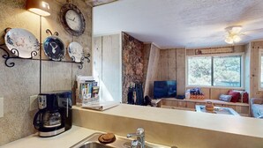 A kitchen with a coffee maker, a sink, and a window with a view of trees. - Close to Lifts | WIFI | Easy Access | Pinetree 318 (Angel Fire)