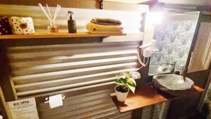 A bathroom with a towel rack, a soap dispenser, a potted plant, and a sink. - Healing Garden Cabins - Villa Uluwatu (Tallebudgera Valley)