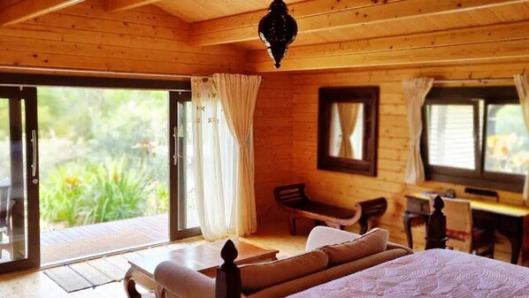 Una habitación de cabaña de madera con una cama, un escritorio y una silla.